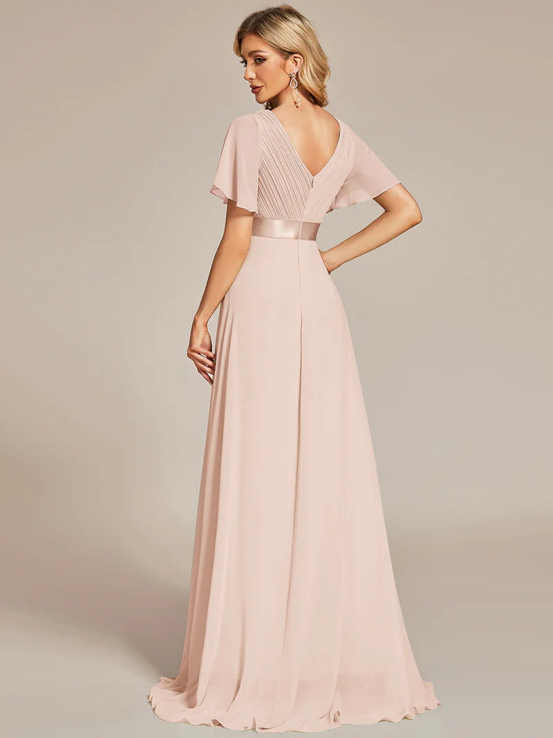 Woman wearing a pink evening gown against a neutral background