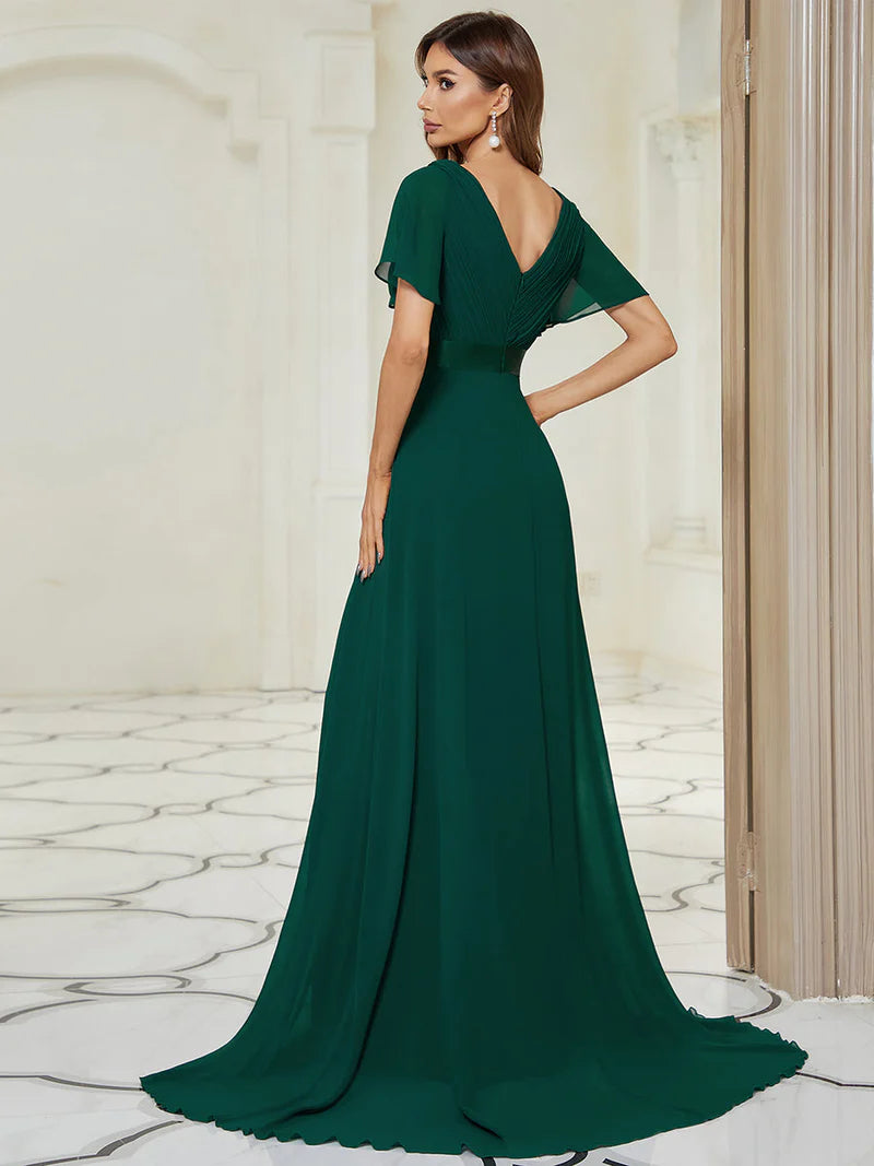 Woman wearing a dark green evening gown in an elegant interior setting