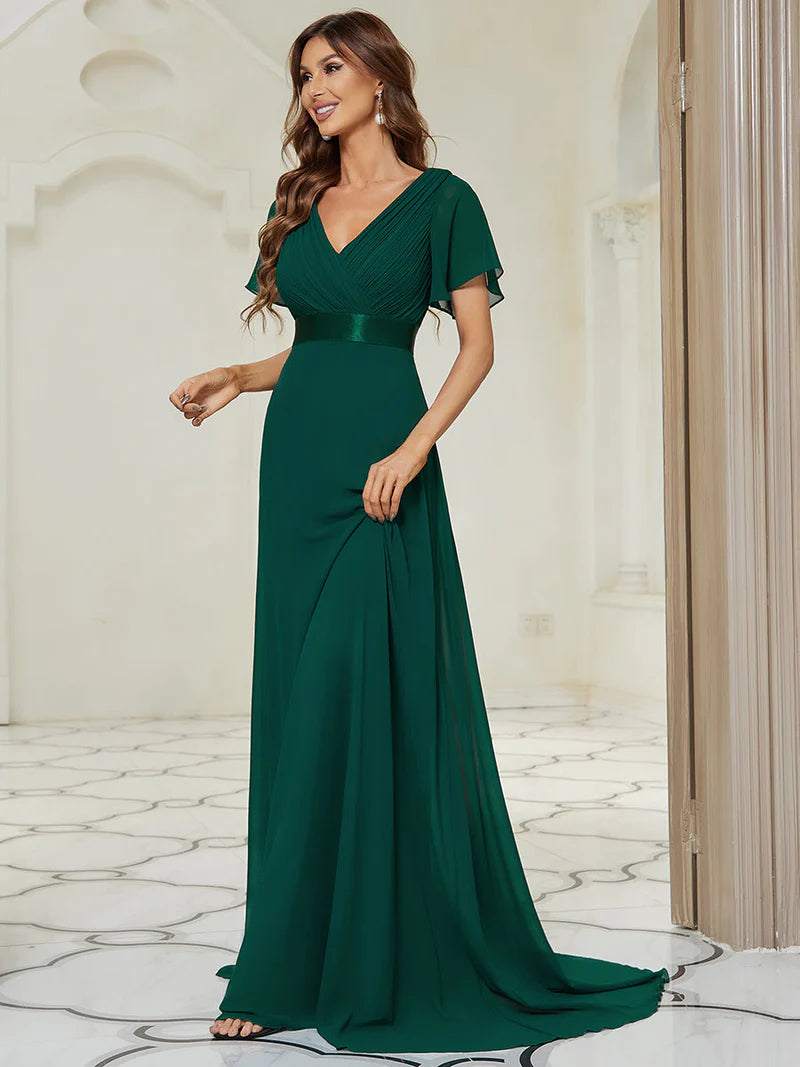Woman wearing a dark green evening gown in an elegant indoor setting