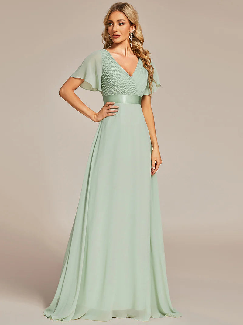 Woman wearing a mint green evening gown with a plain background