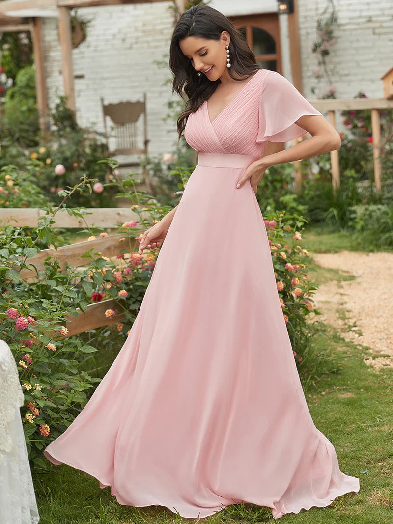 Woman in a pink dress standing in a garden