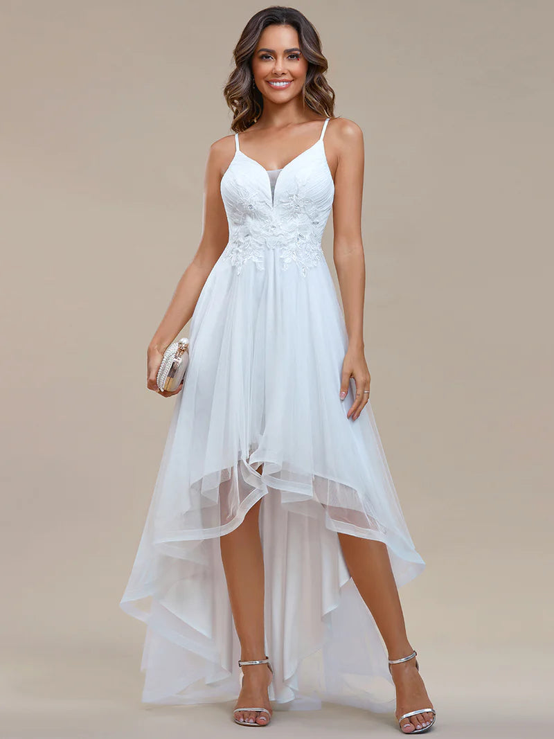 Modern high-low white wedding dress with mesh overlay and floral appliqués