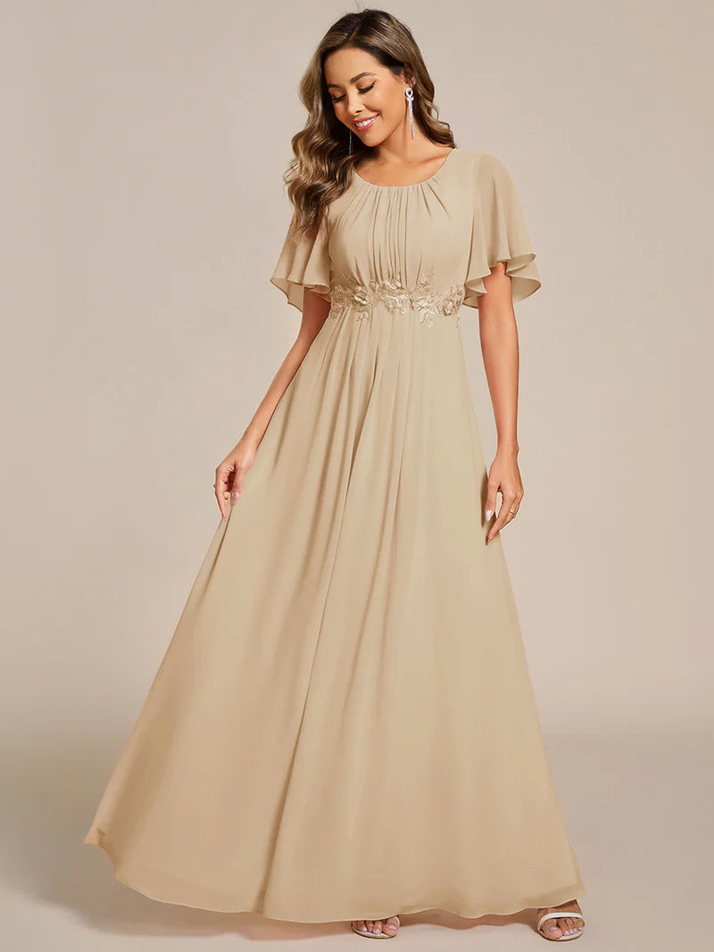 charcoal a-line floor-length evening dress with short sleeves, pleated skirt, and applique embellishments