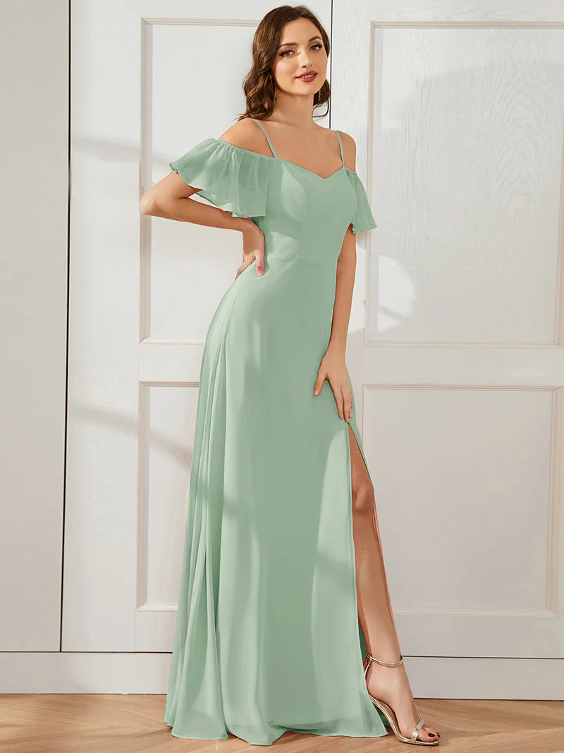 Woman wearing a mint green off-shoulder dress with a slit on a white background