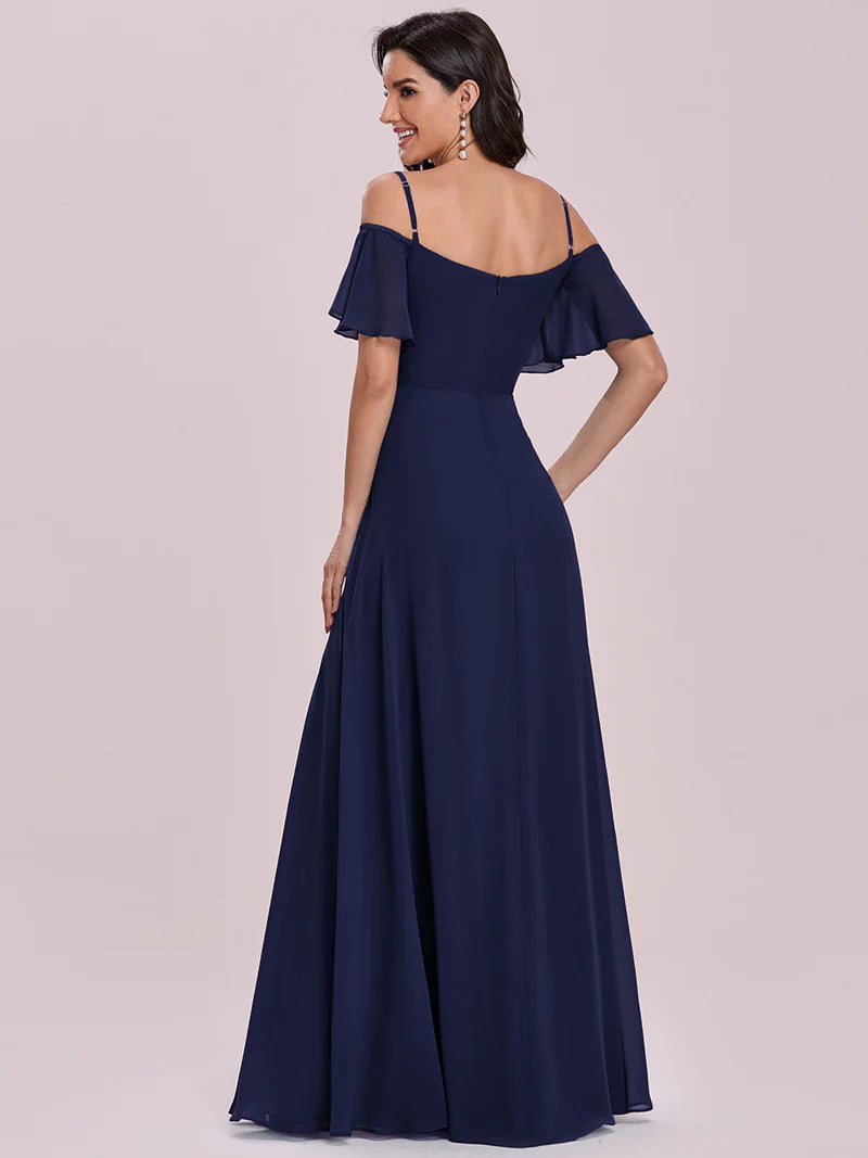 Navy blue off-shoulder evening gown on a model against a light pink background