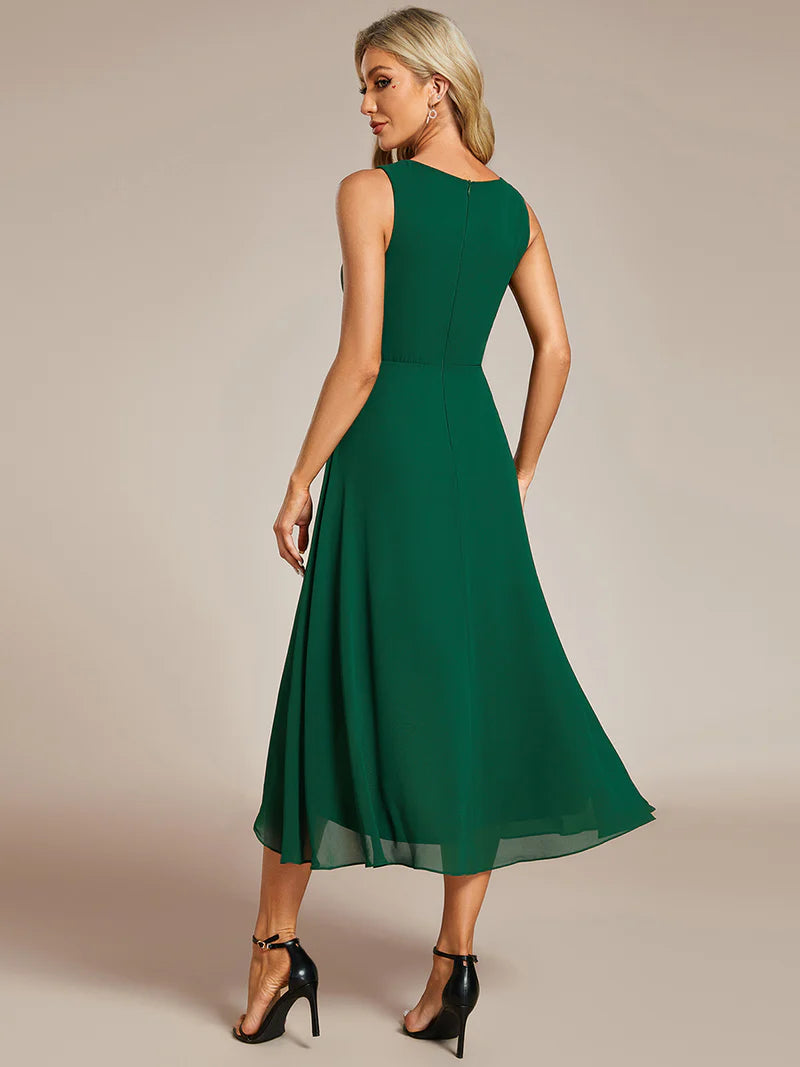 Dark green tea-length chiffon wedding guest dress with V-neckline and delicate appliqués