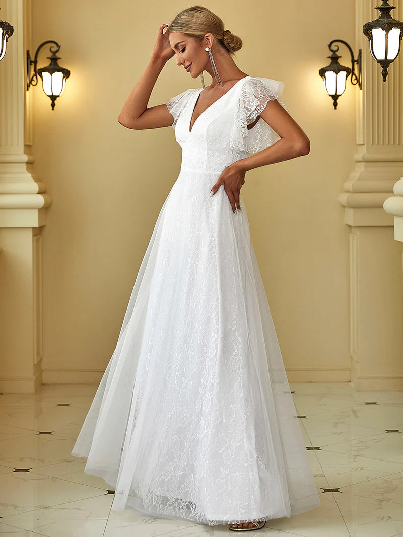 Woman wearing a white lace dress in an elegant indoor setting