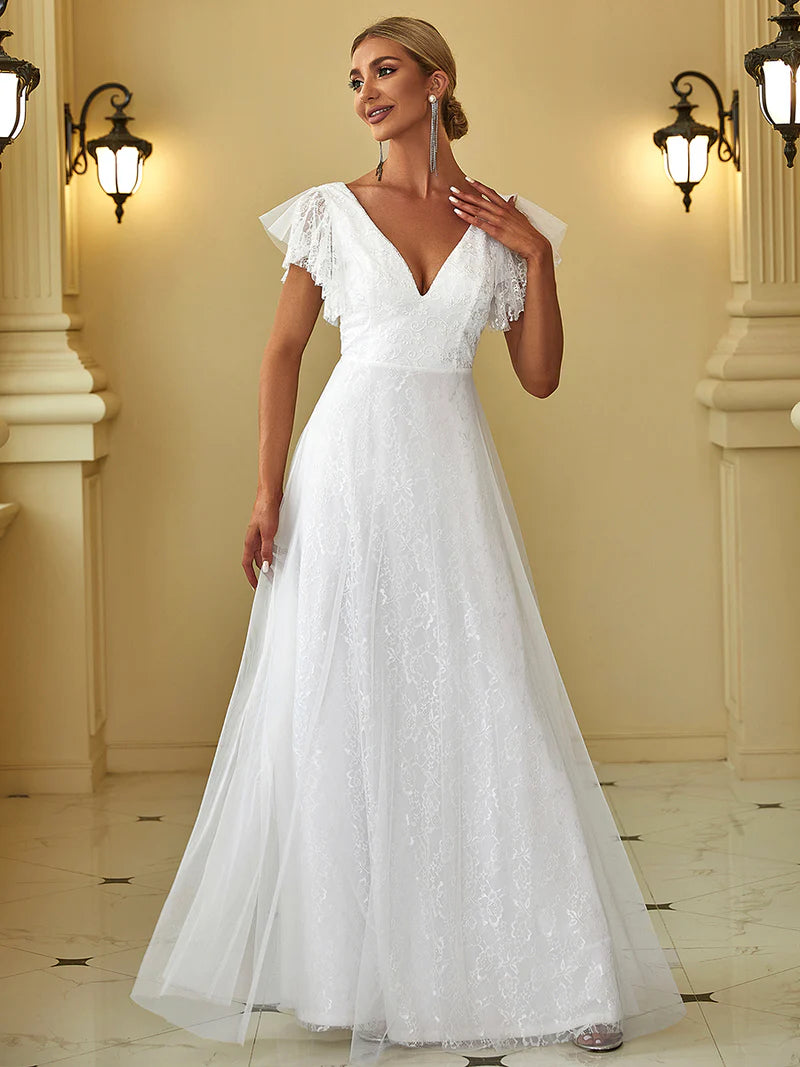Woman wearing a white wedding dress in an elegant indoor setting.