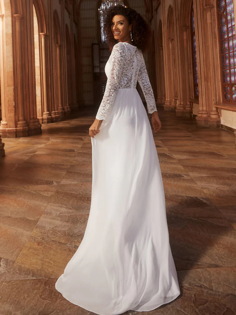 Woman in a white wedding dress with lace sleeves standing in a cathedral.