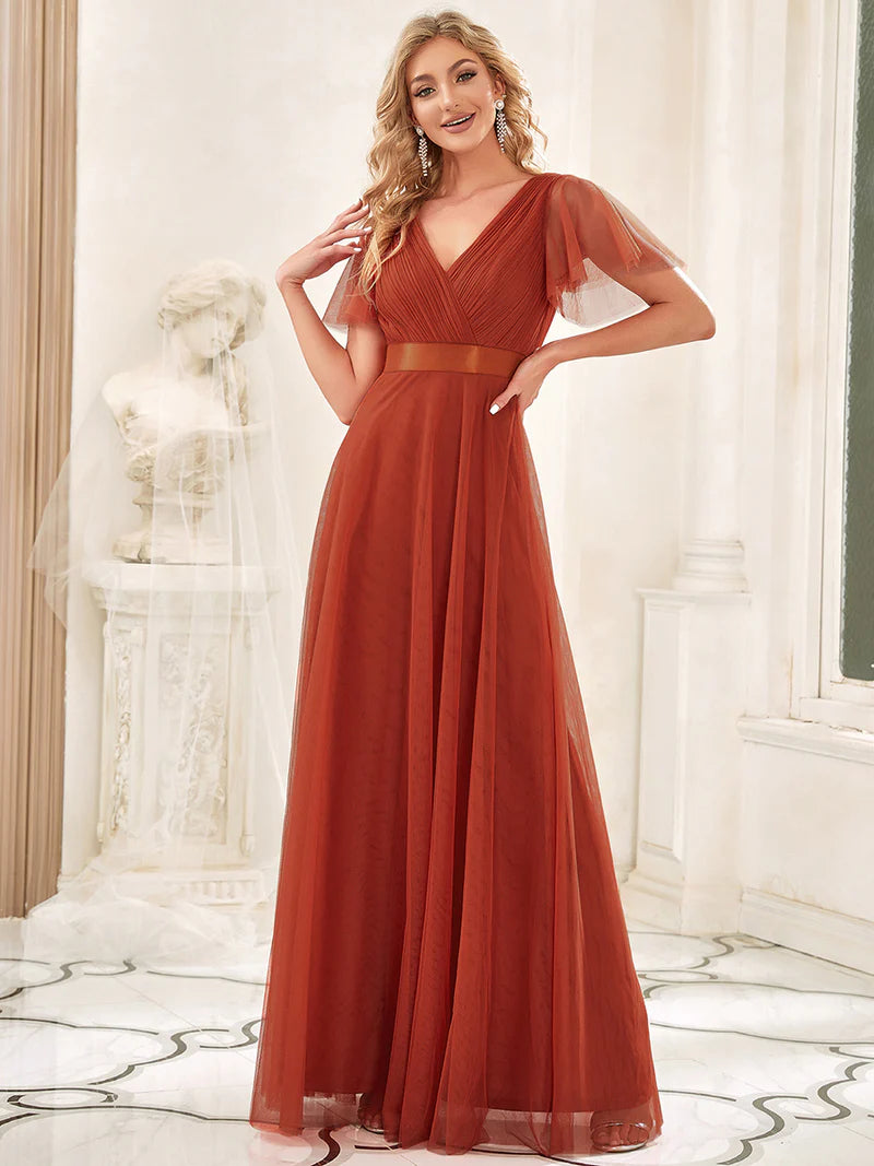 Woman wearing a long rorange dress in an elegant indoor setting