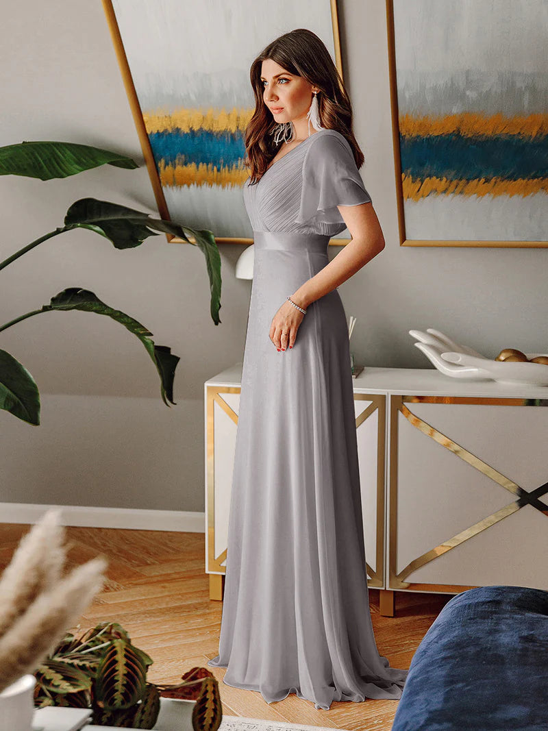 Grey glamorous evening gown with double V-neckline, ruffle detailing, and padded bodice
