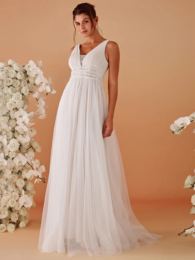 Woman wearing a ivory wedding dress against a beige background with floral decorations.