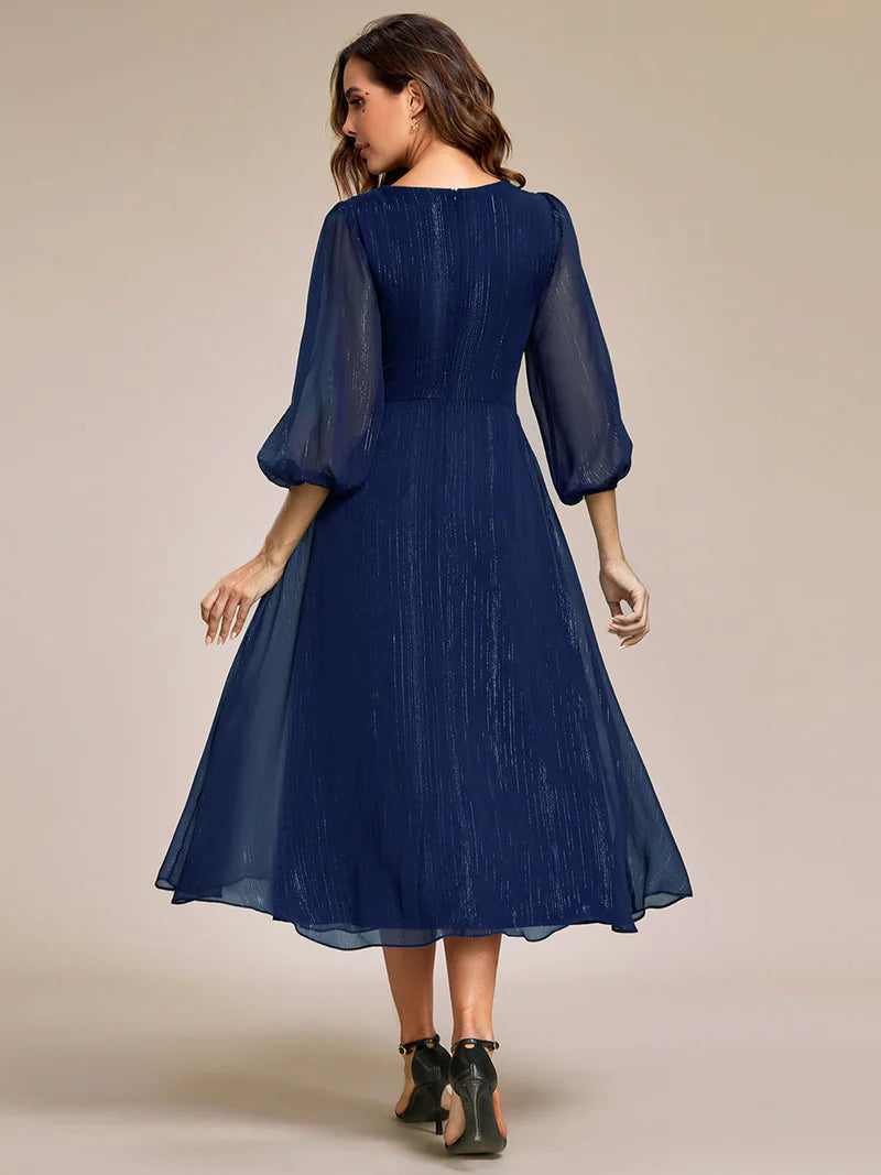 Navy blue elegant shiny chiffon wedding guest dress with long sleeves and flowing silhouette