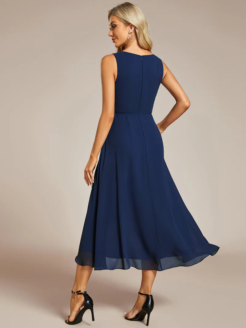 Navy blue tea-length chiffon wedding guest dress with V-neckline and delicate appliqués