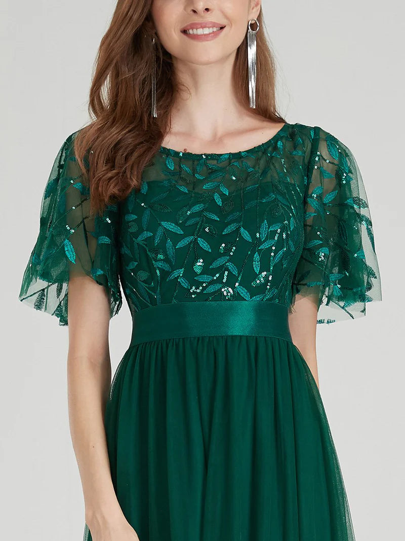 Green dress with floral lace overlay on a plain background
