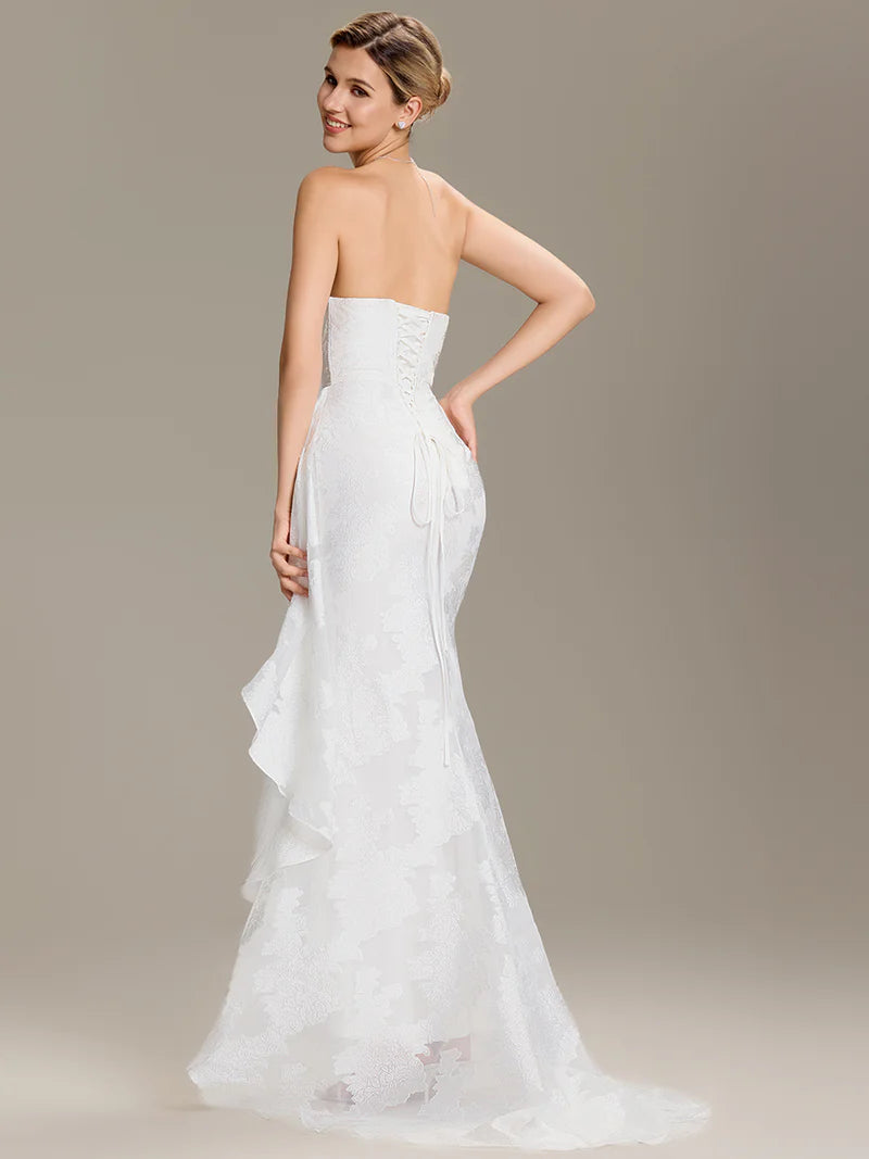 Elegant floor-length white bridal gown featuring strapless neckline, cold shoulder cut, and fishtail hem