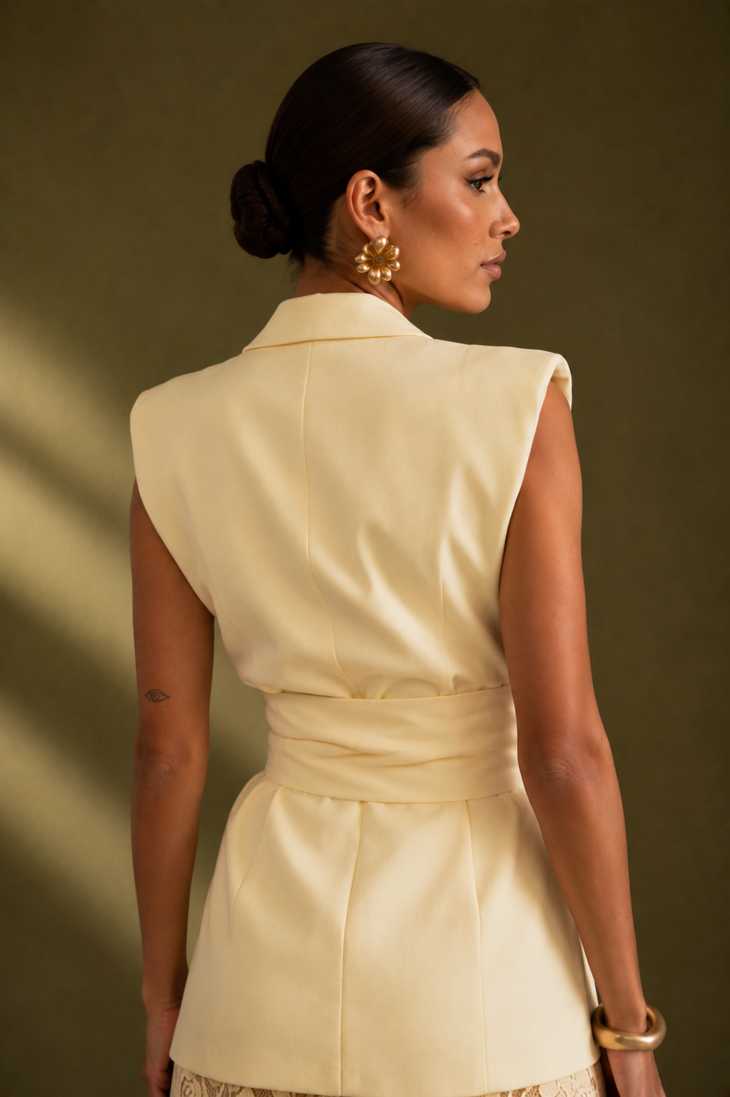 Woman wearing a beige dress against a brown background