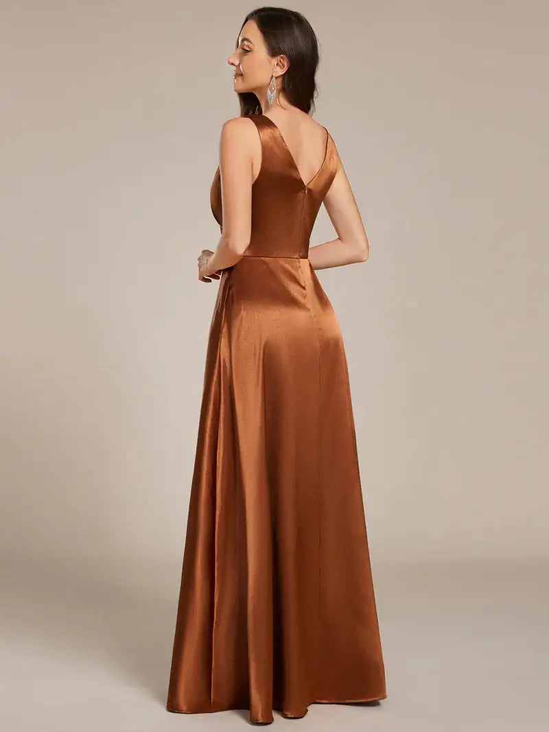 Woman wearing a long Copper dress against a plain background