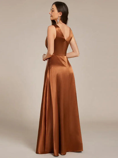 Woman wearing a long Copper dress against a plain background