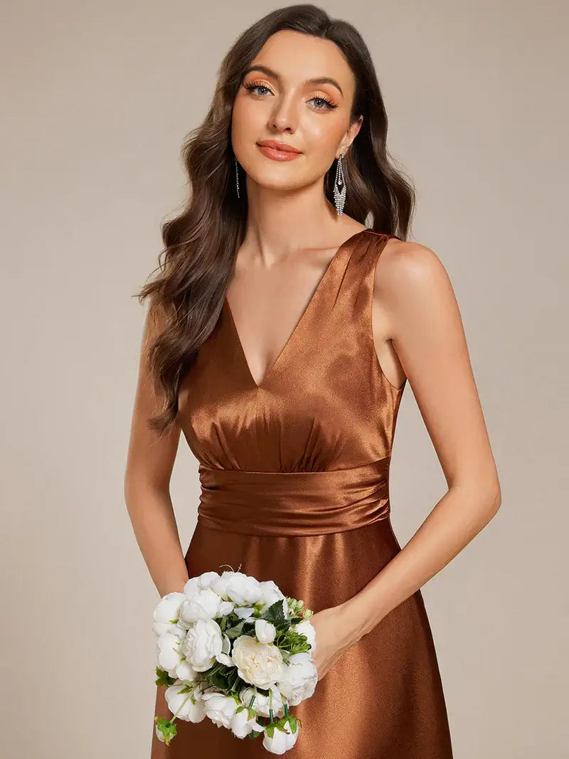 Woman in a Copper dress holding a bouquet of flowers against a beige background
