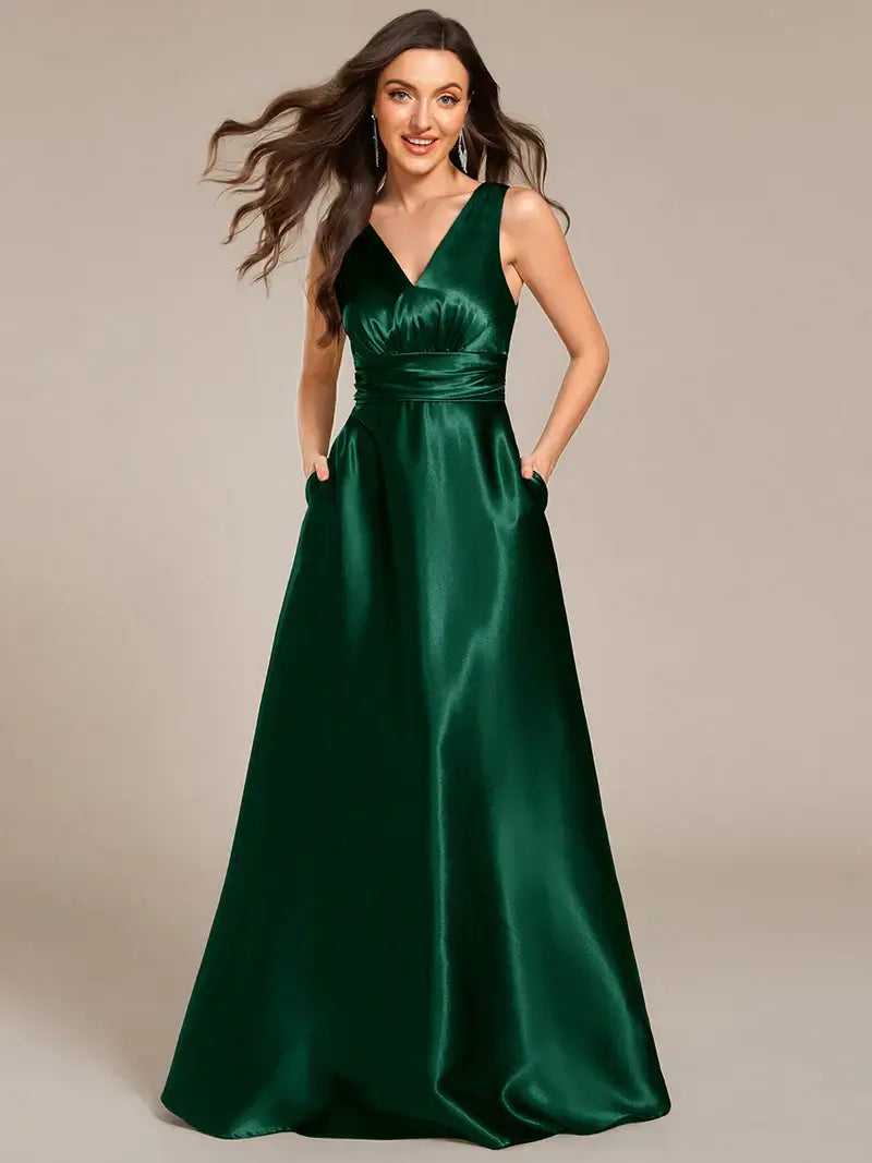 Woman wearing a Dark Green satin dress against a beige background