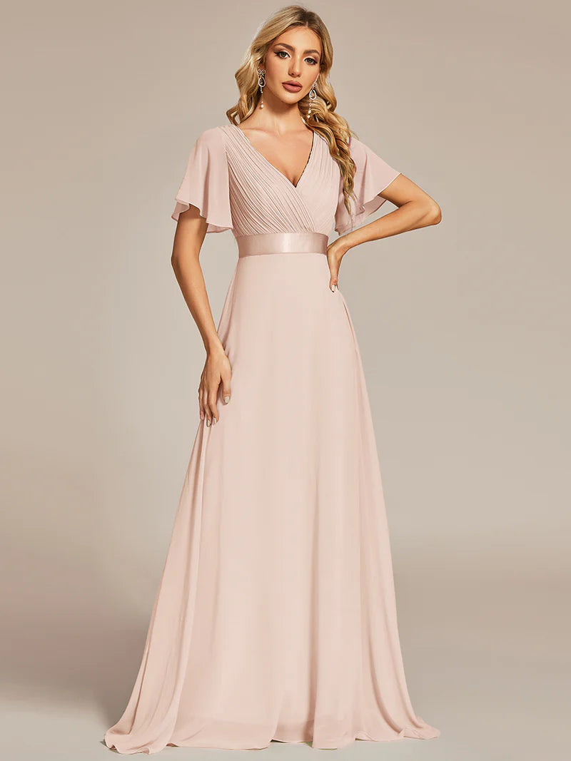 Woman wearing a long pink dress against a neutral background