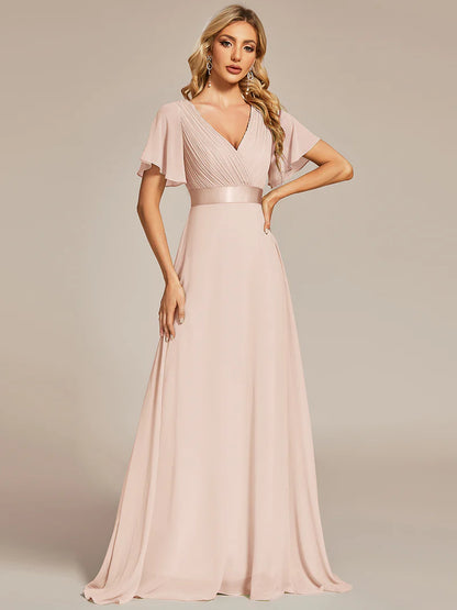 Woman wearing a long pink dress against a neutral background