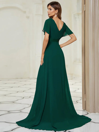 Woman wearing a dark green evening gown in an elegant interior setting