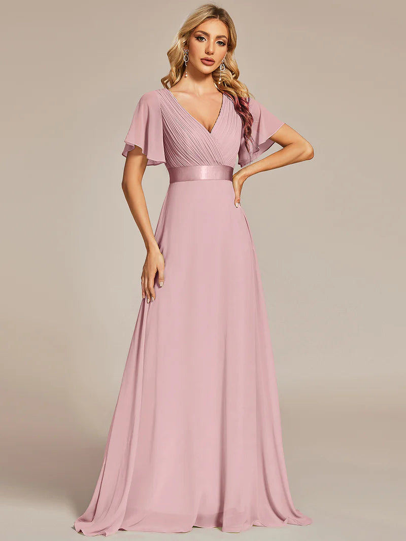 Woman wearing a dusty rose evening gown against a beige background