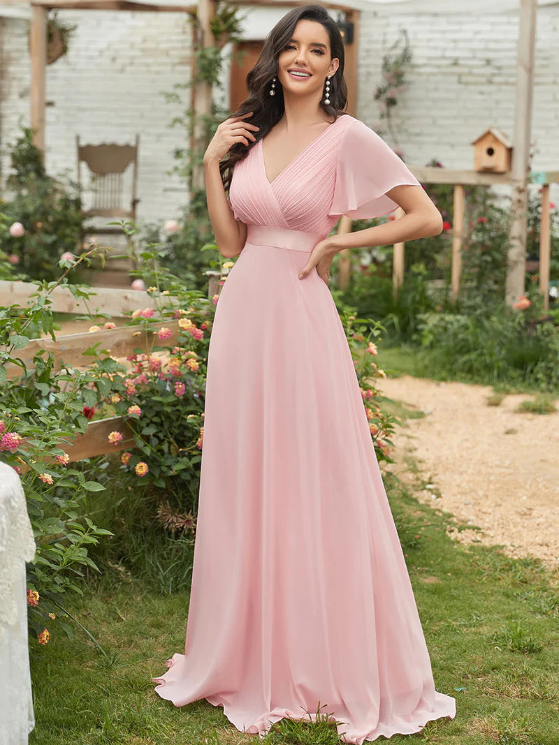 Woman in a pink dress standing in a garden