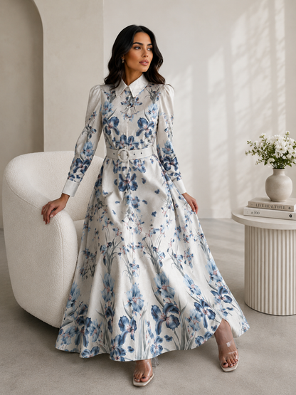Woman in a floral dress sitting on a white chair in a modern interior setting.