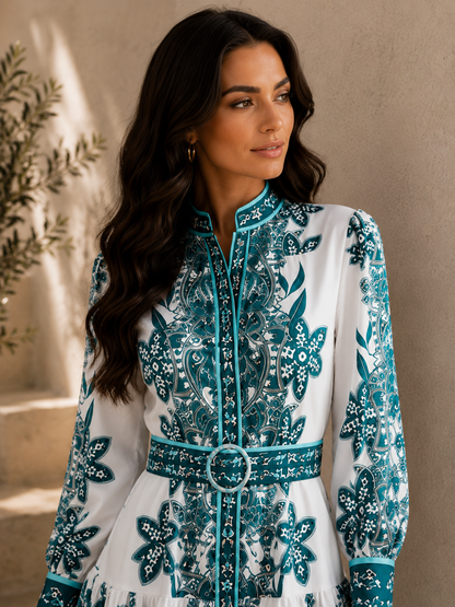 Woman wearing a white dress with blue floral patterns against a neutral background