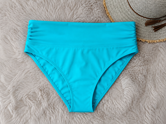 Turquoise bikini bottom on a textured gray surface