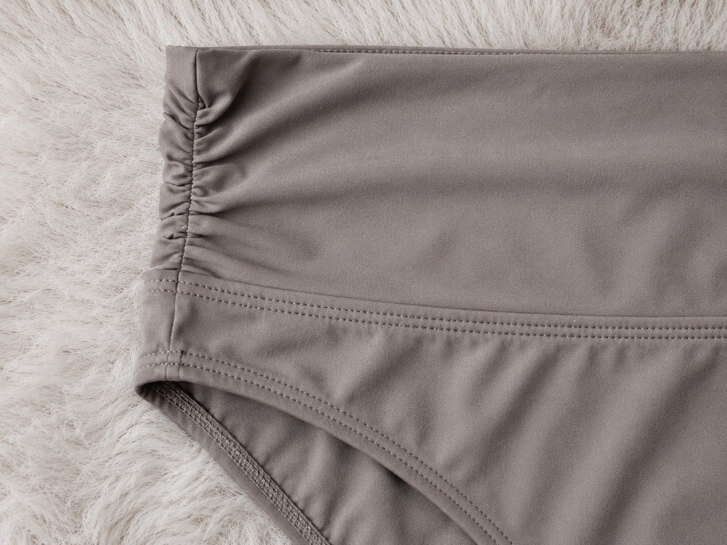 Close-up of gray underwear on a textured white background
