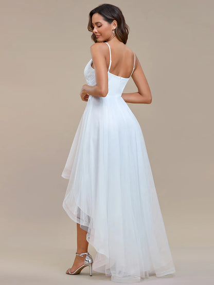 Modern high-low white wedding dress with mesh overlay and floral appliqués