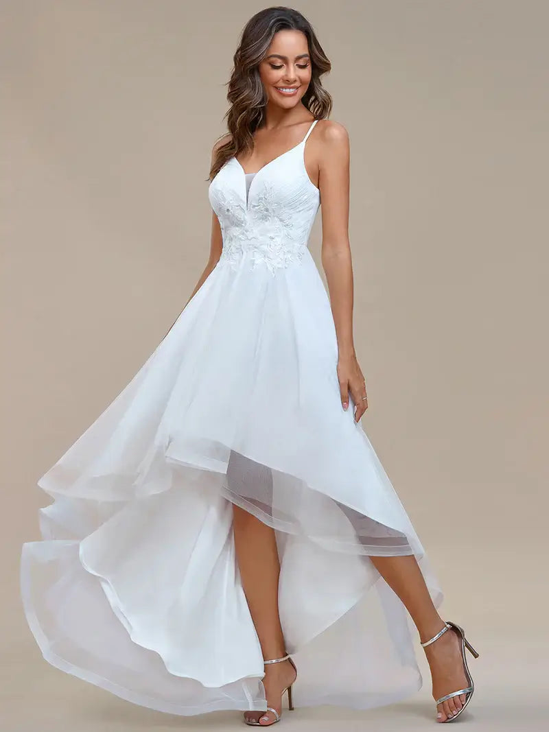 Modern high-low white wedding dress with mesh overlay and floral appliqués