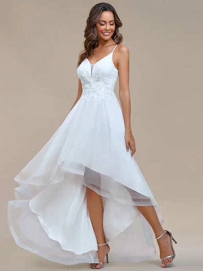 Modern high-low white wedding dress with mesh overlay and floral appliqués