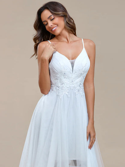 Modern high-low white wedding dress with mesh overlay and floral appliqués