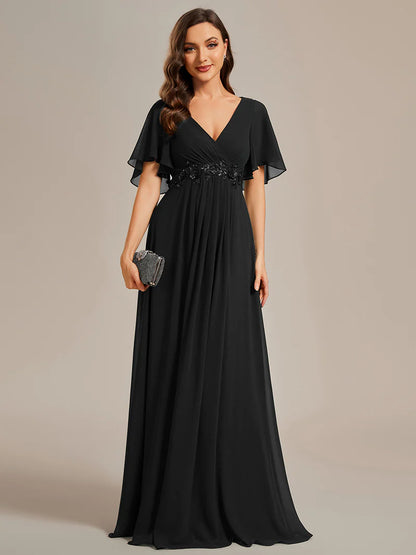 Elegant black bridesmaid dress with V-neckline, pleated skirt, and floral appliqués
