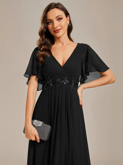 Elegant black bridesmaid dress with V-neckline, pleated skirt, and floral appliqués