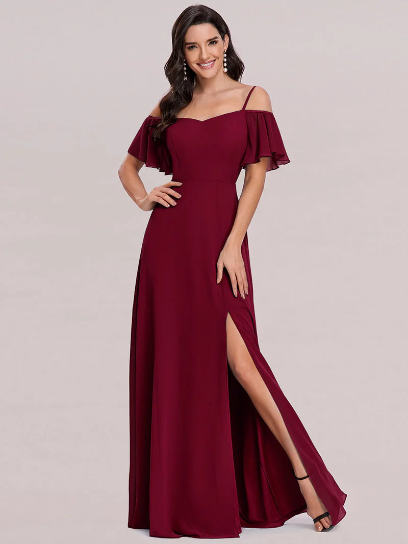 Burgundy off-shoulder gown with a slit on a plain background