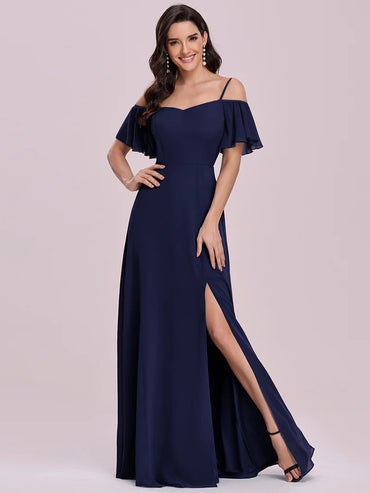 Navy blue off-shoulder gown with a slit on a light pink background