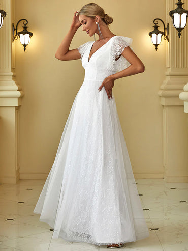 Woman wearing a white lace dress in an elegant indoor setting
