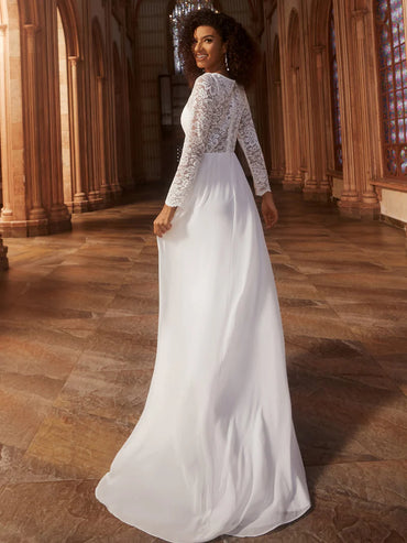 Woman in a white wedding dress with lace sleeves standing in a cathedral.