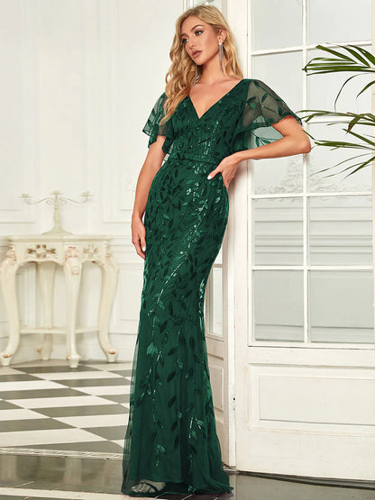 Green V-neck fishtail party dress with shimmering leaf sequin embellishment.