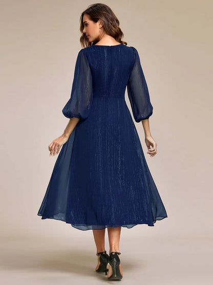 Navy blue elegant shiny chiffon wedding guest dress with long sleeves and flowing silhouette