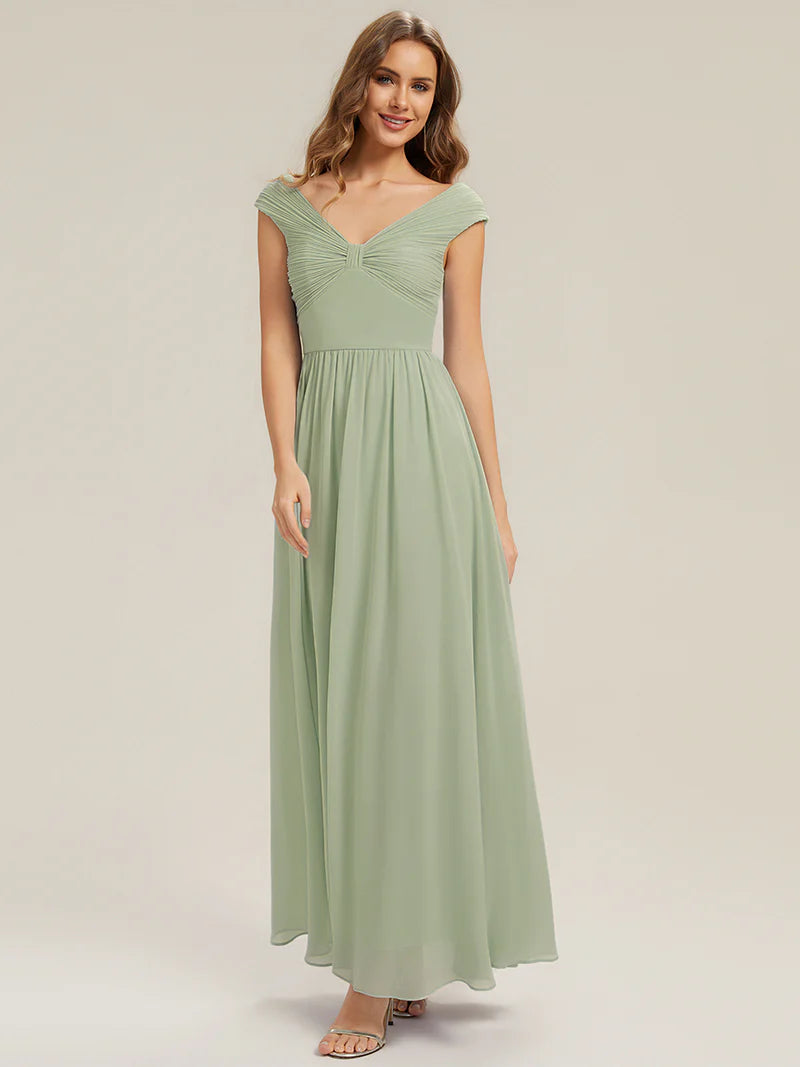 Woman wearing a long mint green dress on a plain background