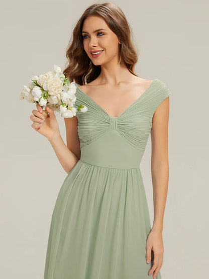 Woman in a green dress holding a bouquet of flowers against a plain backgroundmint 