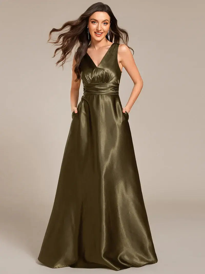 Woman wearing a olive green satin gown against a beige background