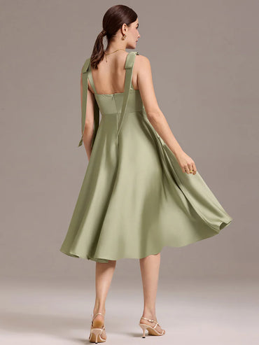 Sage green satin midi dress with V-neckline, tie-shoulder straps, and sleeveless style